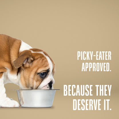 Dog looking into a bowl with text 'Picky-eater approved. Because they deserve it.' on a beige background